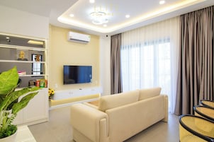 Junior Villa, Garden View | Living area | Flat-screen TV