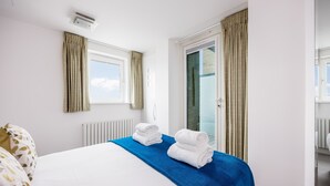 Una habitación de hotel con una cama, una ventana, un radiador y una puerta.