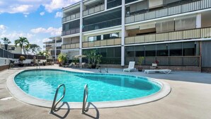 A modern hotel with a rooftop pool, multiple balconies, and outdoor seating areas. - Summer Deal Updated 2BR Kona Condo Near Ocean and Downtown Kona (Kailua-Kona)