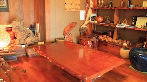 Ein Holztisch mit glänzender Oberfläche, umgeben von verschiedenen Dekorationsgegenständen und Möbeln.