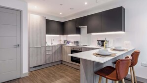 Una cocina moderna con una isla central, electrodomésticos integrados y un diseño minimalista.