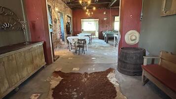 A rustic interior with a large cowhide rug, wooden furniture, and a billiards table.