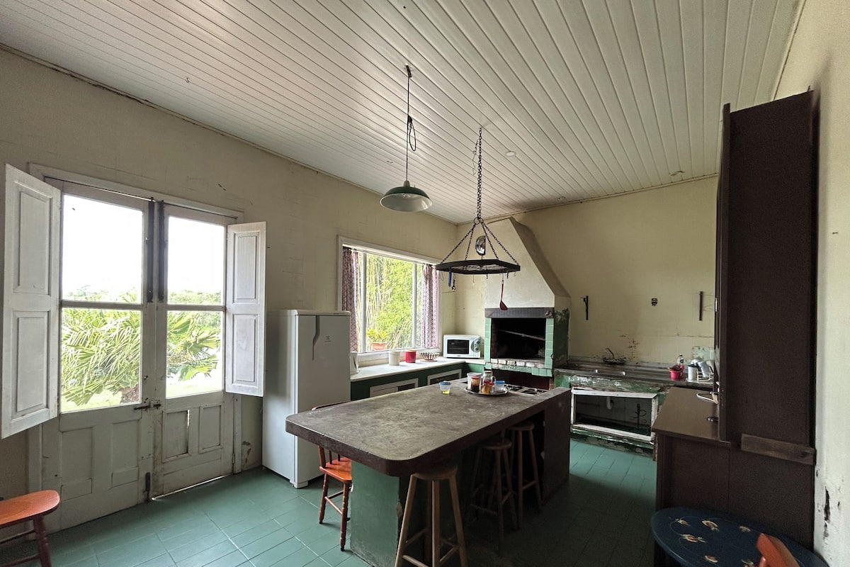 Una cocina con una isla grande, microondas y una lámpara colgante.