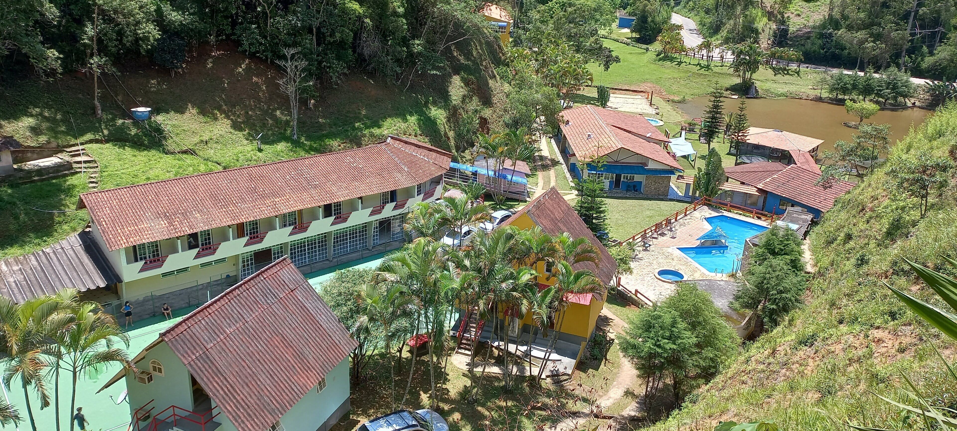 Un complex turístic amb diversos edificis, una piscina i entorn natural.