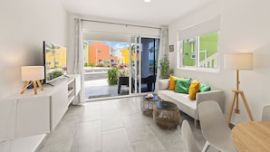 A modern living room with a sofa, a TV, and a dining area. - Punta azul 12A Ocean resort  (Sabana Westpunt)