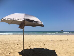 Na praia, espreguiçadeiras, toalhas de praia 