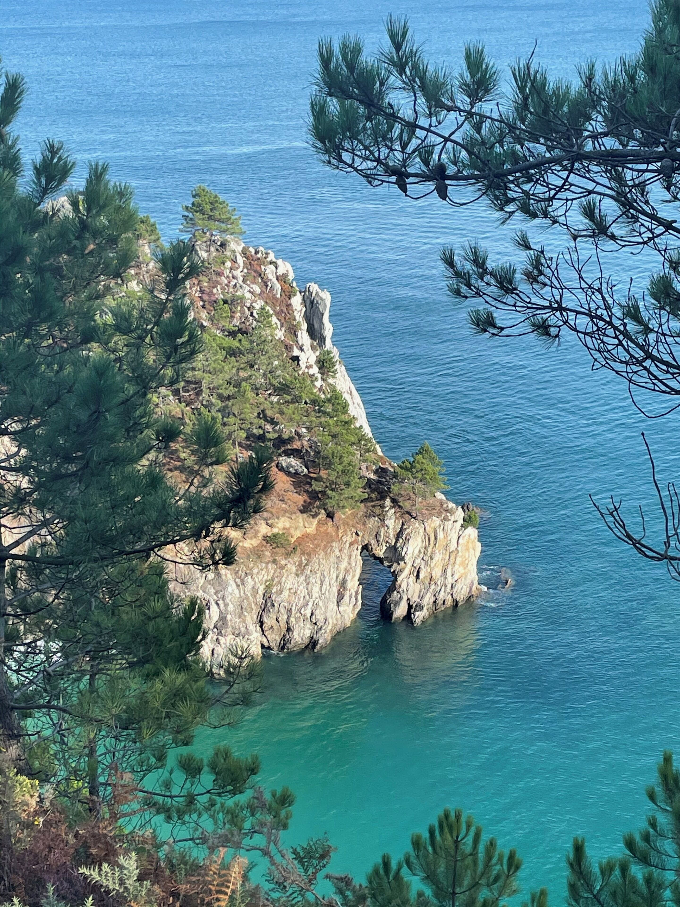 Un paisaje costero con acantilados rocosos y aguas turquesas cristalinas.