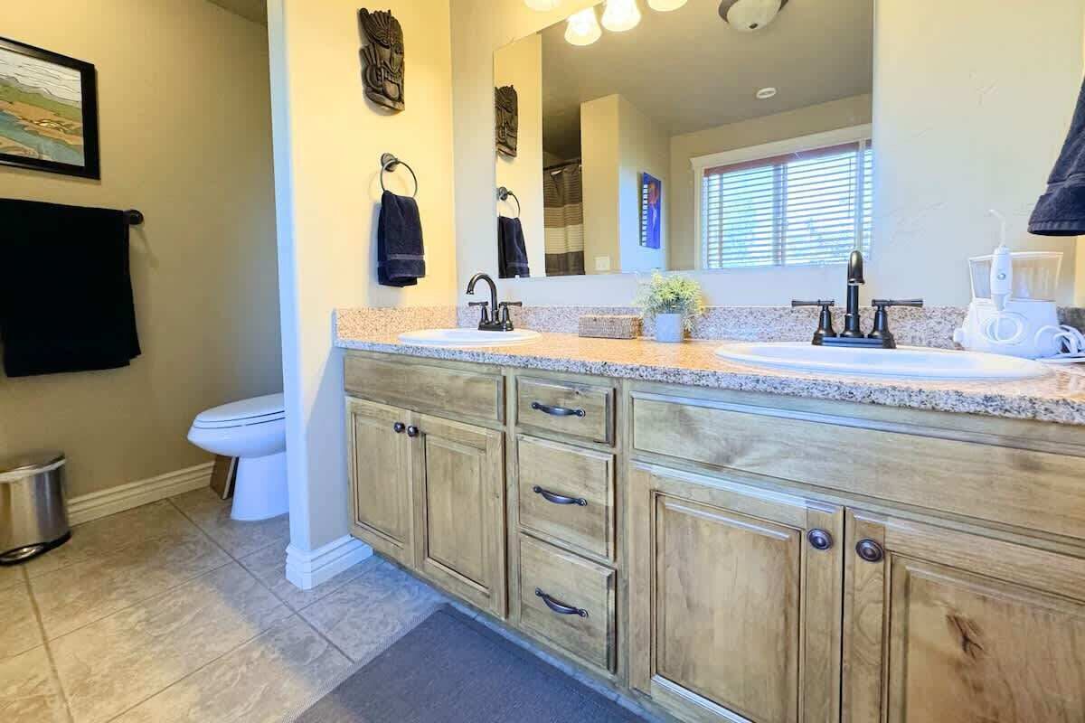 A bathroom with a sink, mirror, and toilet.