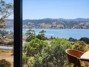 A view from a window overlooking a lake with boats, trees, and distant hills. - The Tamar Ridge Lookout 2Bed 2Bath Suite (Grindelwald)