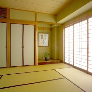 A traditional Japanese room with tatami flooring, sliding doors, and a shoji screen. - Arima Onsen Abrigo (Kobe)