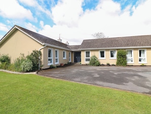 A two-story building with a flat roof, multiple windows, and a paved driveway. - Beech Lodge (Taghmon)