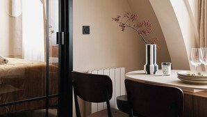 A modern hotel room with a dining area, a bed, and a large window. - Résidence Louvre  (Paris)