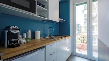 Frigorífico pequeño, horno, placa de cocina y utensilios de cocina