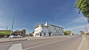 A white hotel with a flat roof and a sign reading "HOTEL".