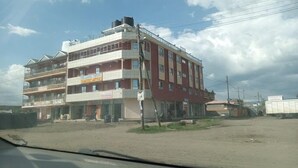 Un edificio de varios pisos con espacios comerciales en la planta baja y viviendas en los pisos superiores.