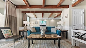 A living room with a sofa, coffee table, and a TV.