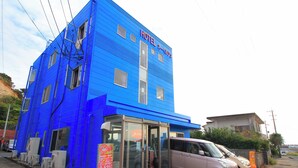 Un bâtiment bleu avec une enseigne indiquant « HÔTEL O-BASEBALL CLUB ».