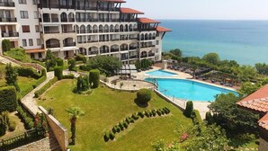 Un hôtel doté de nombreux balcons, d’une piscine et offrant une vue sur la mer.