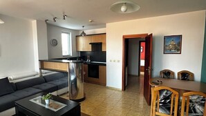 Un salon moderne avec un canapé, une table basse et un coin repas avec des chaises.