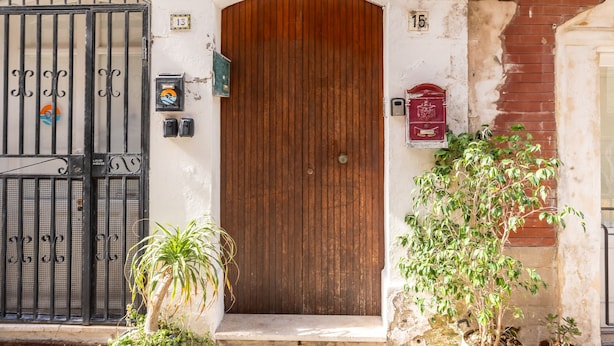 A wooden door with a metal gate, a mailbox, and a potted plant in front. - A 100 Metri da Piazza Duomo di Ortigia by Wonderful Italy (Syracuse)
