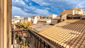A view of terracotta-tiled rooftops and a balcony with potted plants. - A 100 Metri da Piazza Duomo di Ortigia by Wonderful Italy (Syracuse)