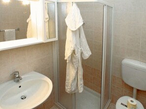 A bathroom with a sink, mirror, shower, and toilet. - Cozy Apartment Near the Beach With Parking Space Included (Lignano Sabbiadoro)