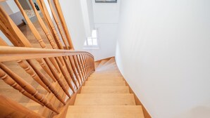 A wooden staircase with a handrail leading to an upper floor. - LIBORIA Alpenblick country house (Uffing am Staffelsee)