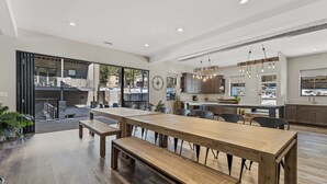 Een ruime keuken met een groot eiland, houten vloeren en moderne verlichting.