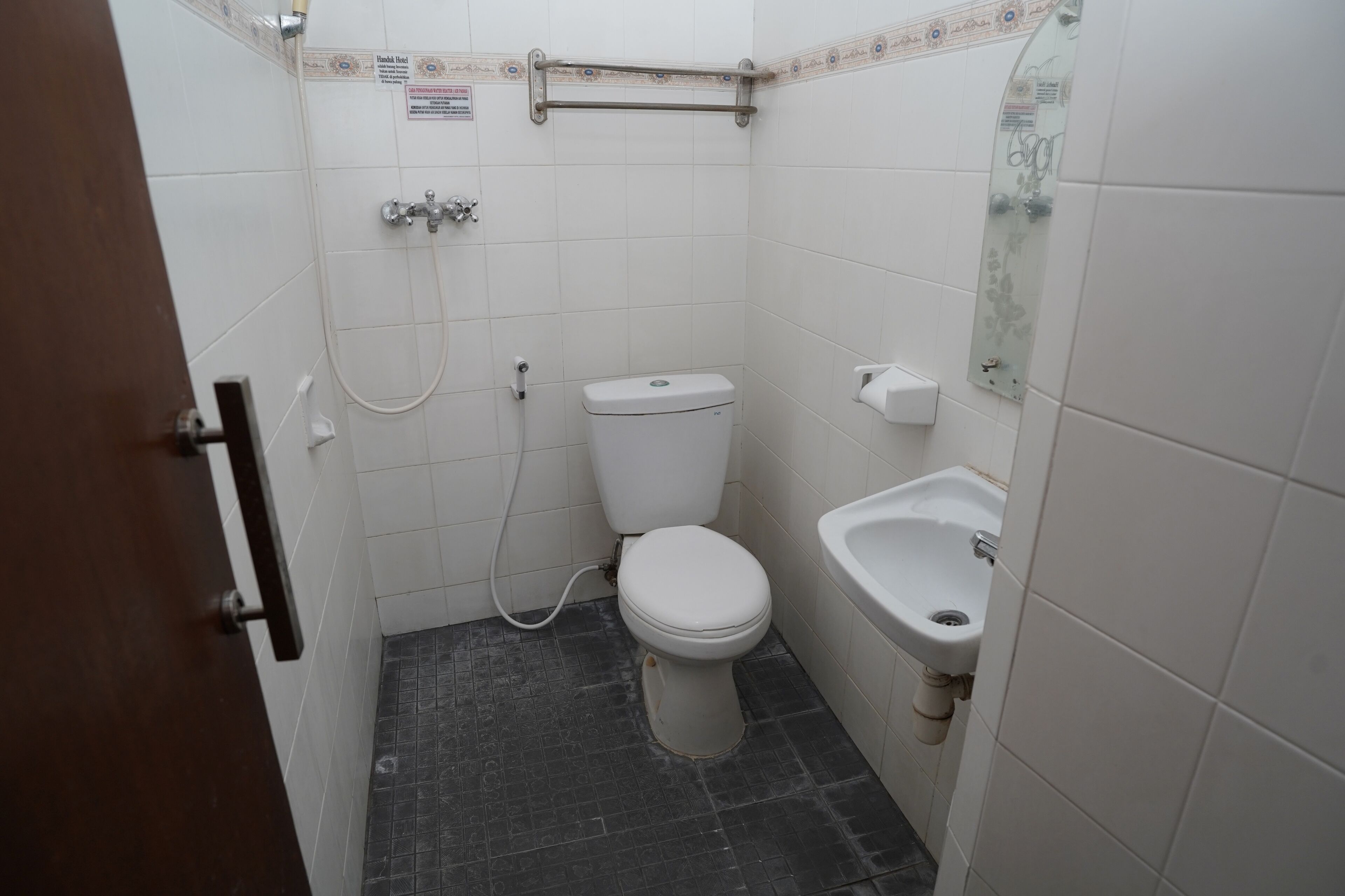 A small, compact bathroom with a toilet, bidet, and sink.