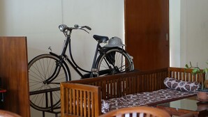 A room with a wooden bench, a bicycle, and a potted plant. - Grha Somaya (Yogyakarta)