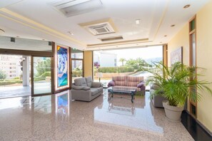 Un vest íbulo de hotel con piso pulido, zona de estar y ventanas amplias que ofrecen vistas al exterior.