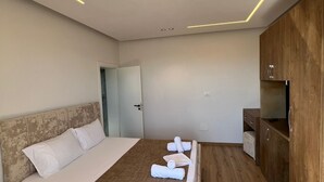 Una camera d'albergo moderna con un letto, pavimento in legno e un armadio in legno.