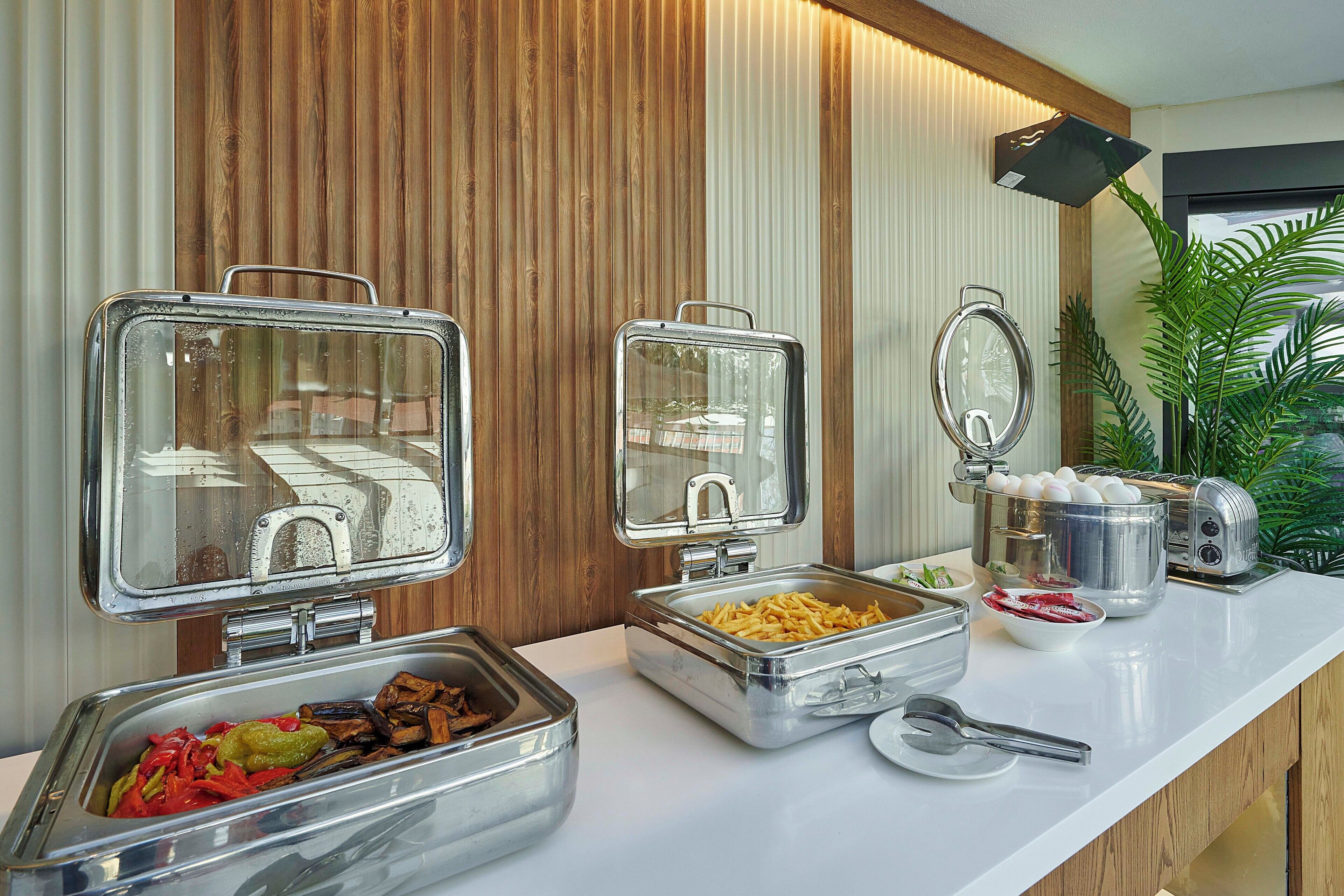 Una mesa de buffet con diferentes recipientes de comida y un tostador.