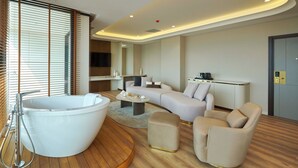 A modern spa room with a large bathtub, a sofa, and a coffee table. - Çırağan Hotel Bosphorus (Istanbul)