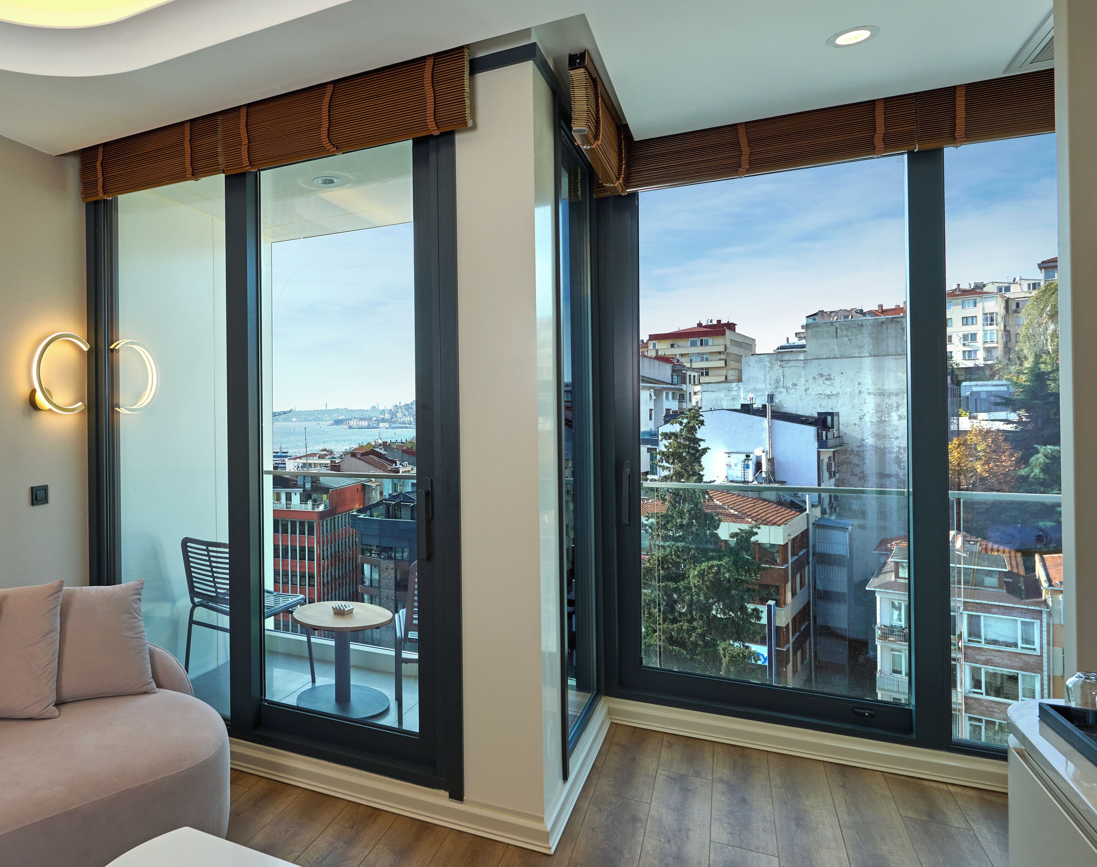 Una sala de estar moderna con amplios ventanales, un sofá, una mesita y un sillón.