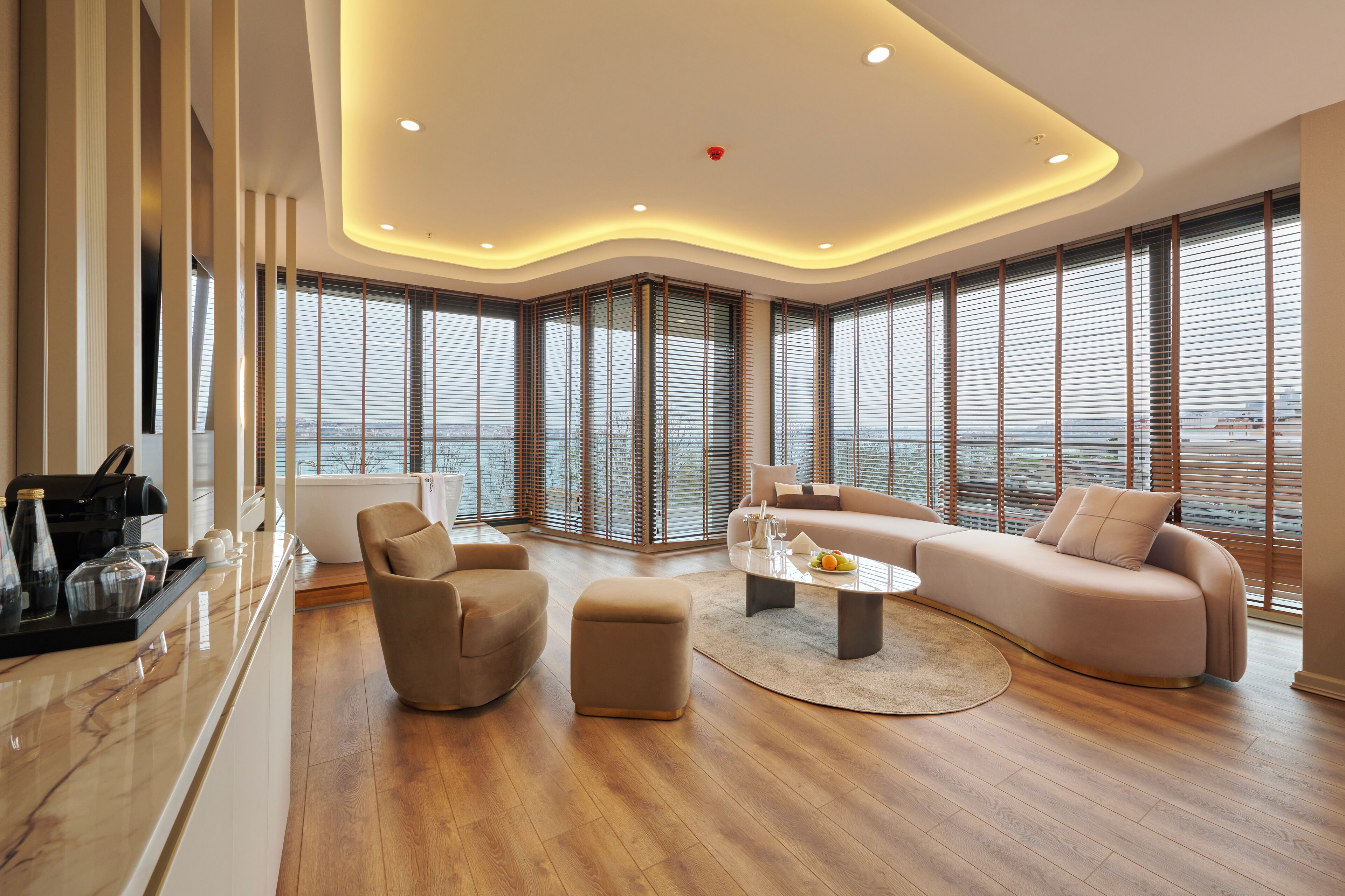 A modern living room with a sofa, armchair, ottoman, and coffee table.
