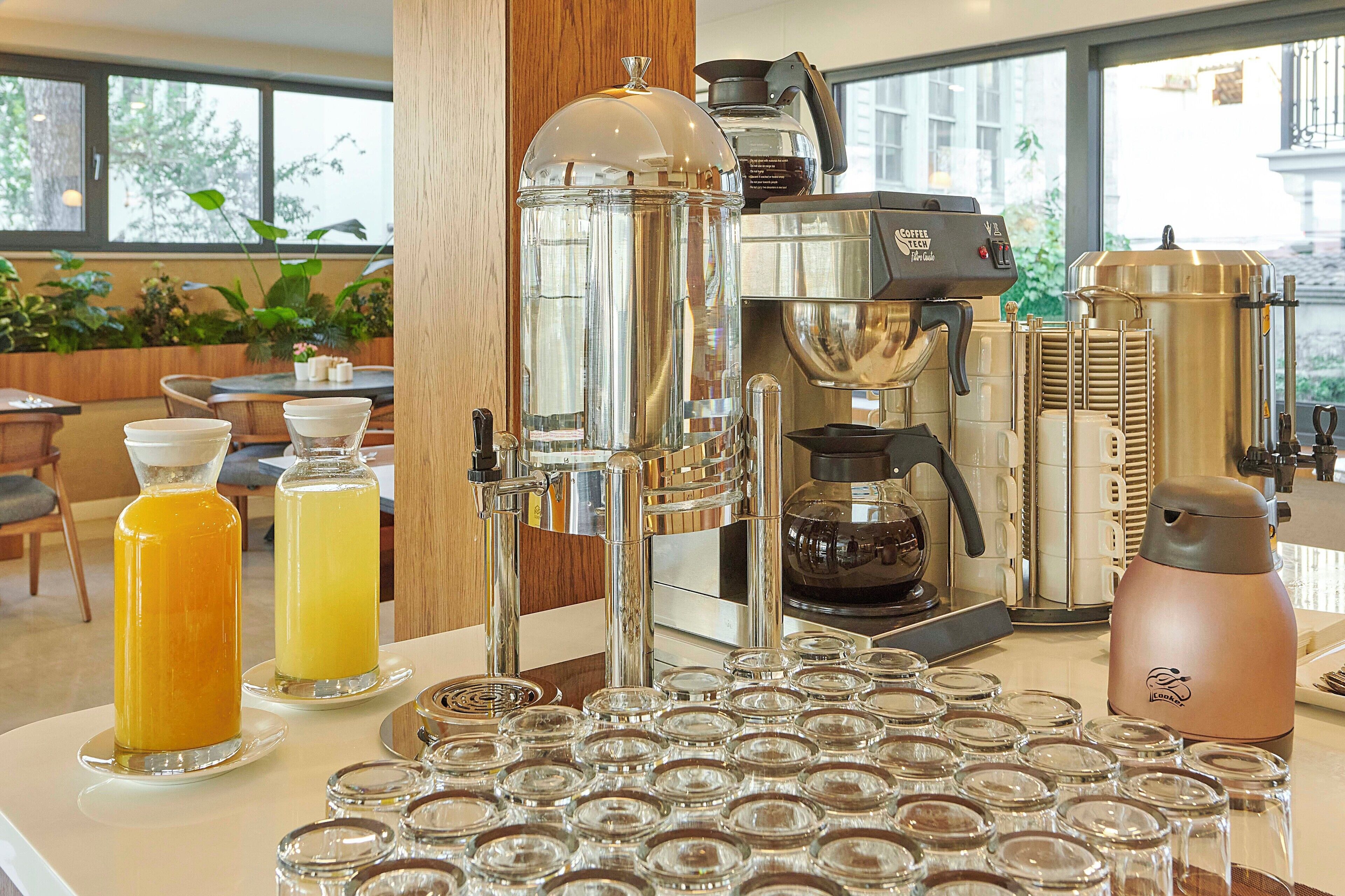 A coffee bar with espresso machines, a coffee press, and a variety of glass containers.