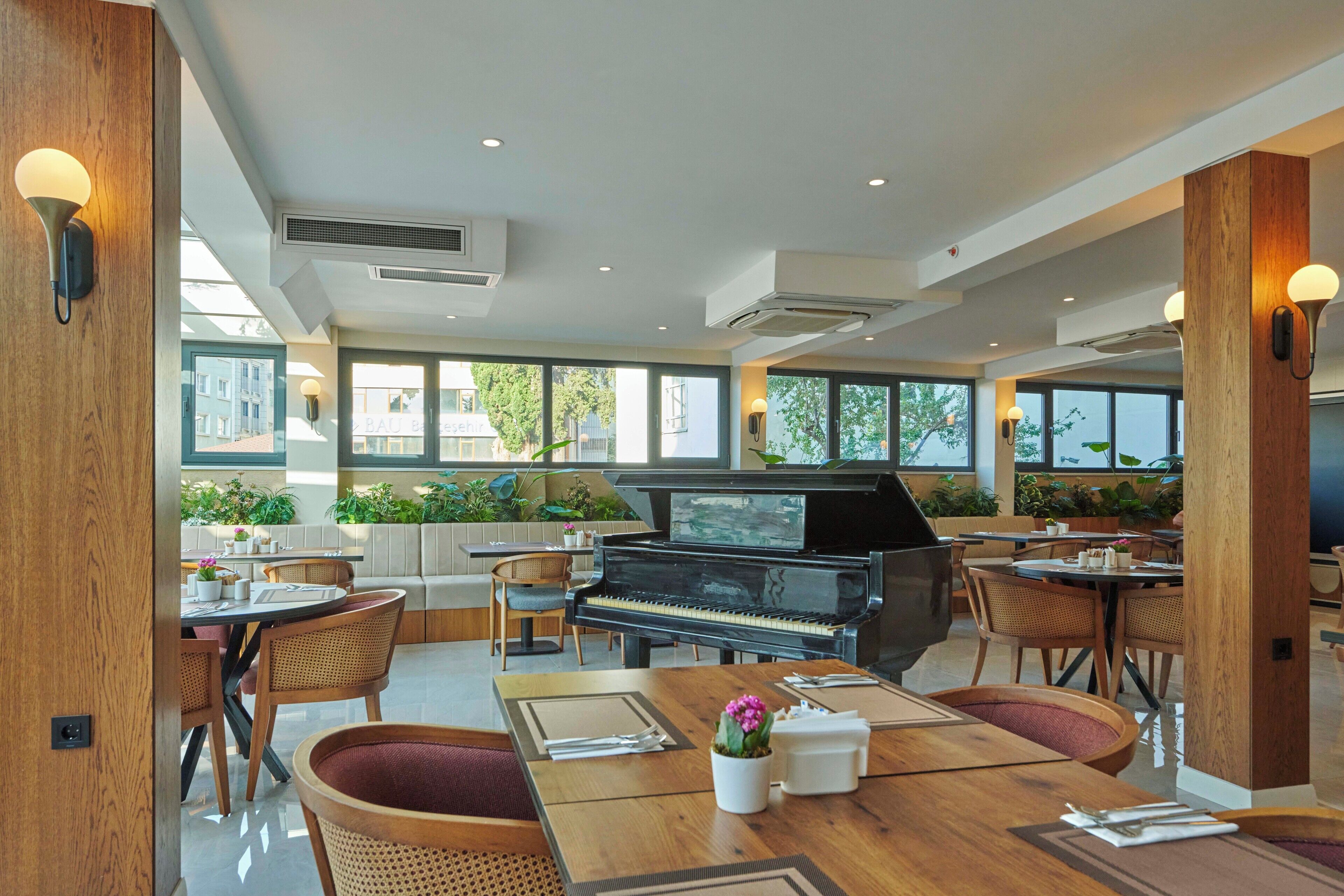 A spacious room with a piano, dining area, and large windows.