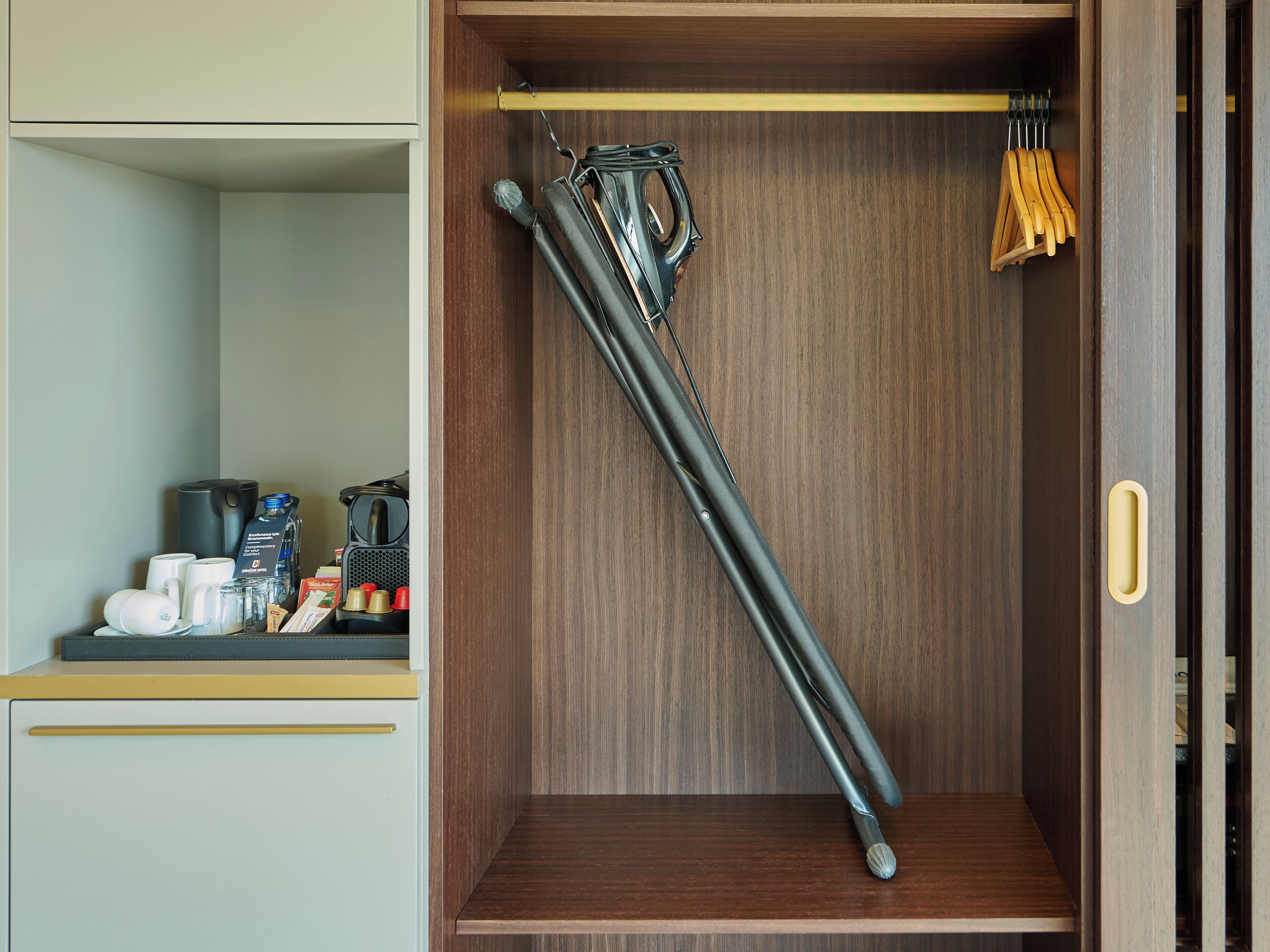 A compact kitchen with a wooden cabinet, a coffee machine, and a kettle.