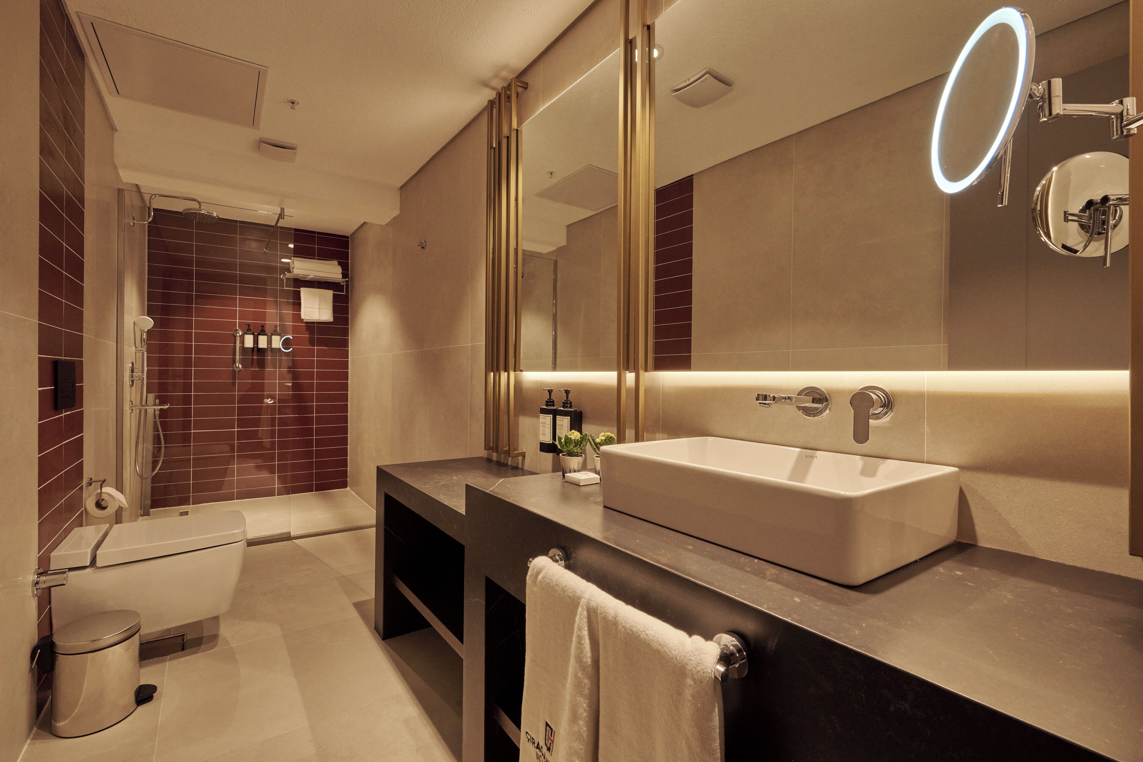 Un baño moderno con un espejo grande, una bañera y un lavabo.