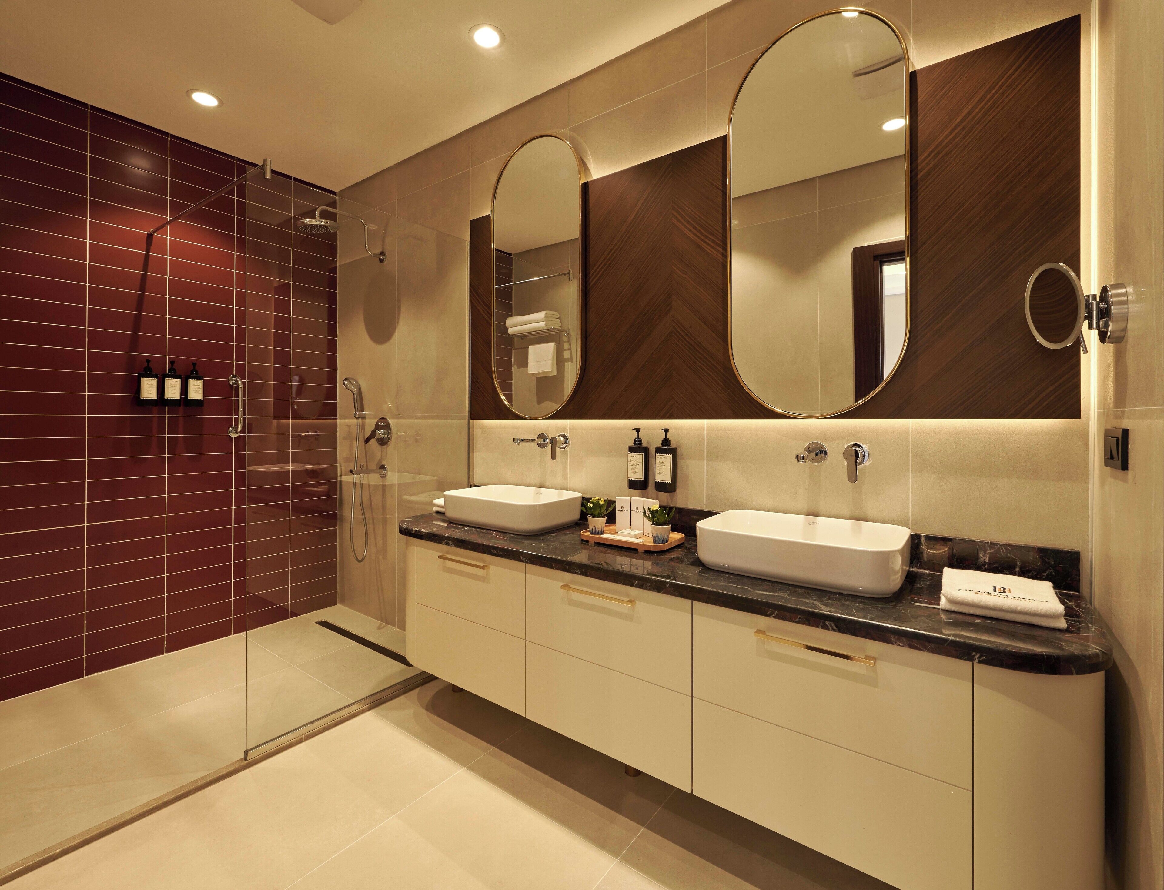 Un bagno moderno con due lavabi, un grande specchio e uno spazio doccia.