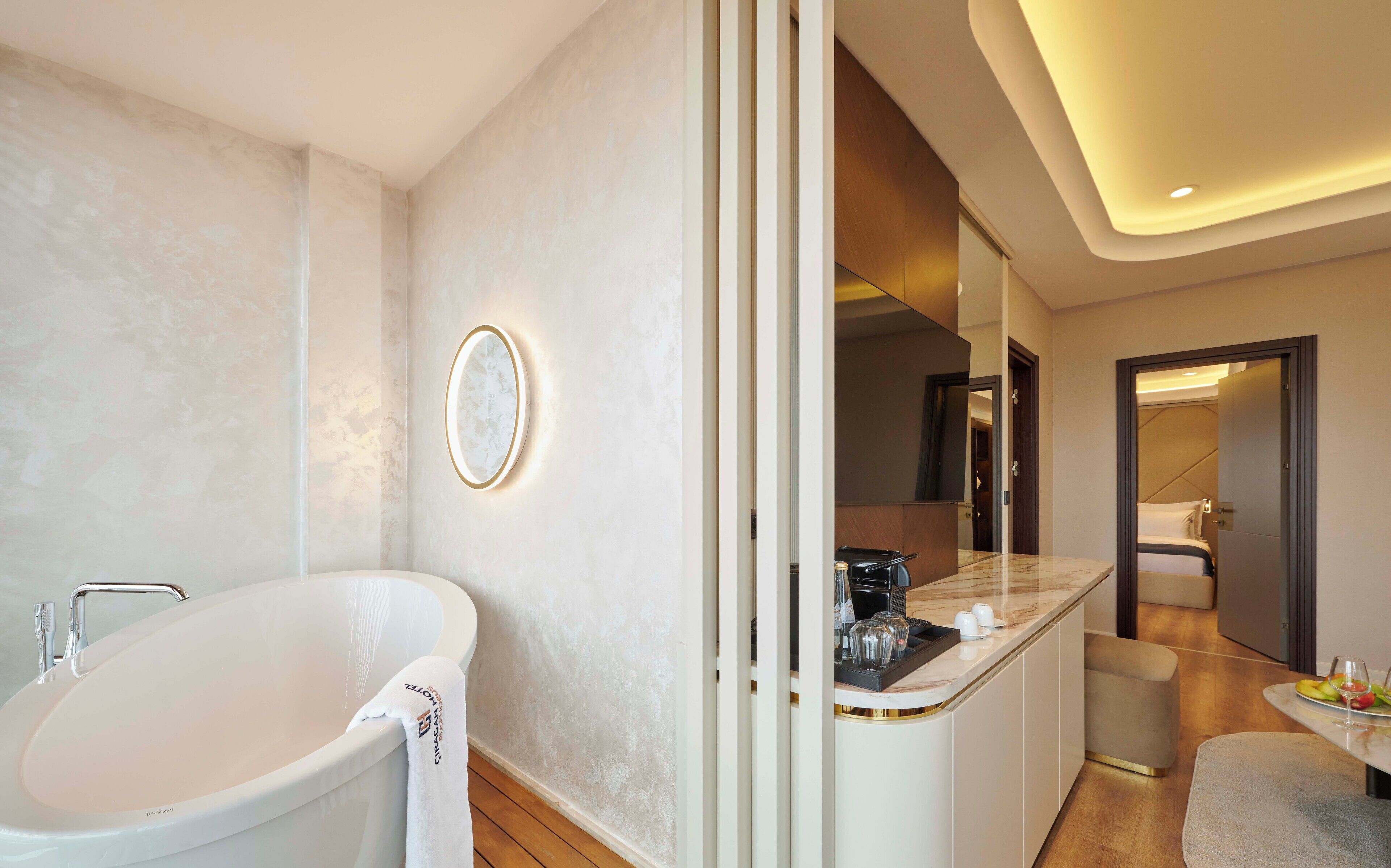 A modern bathroom with a freestanding bathtub, a vanity with a mirror, and a countertop with toiletries.