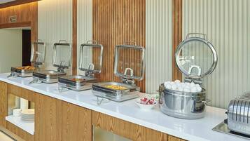 A buffet setup with various food containers and a toaster.