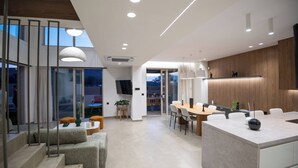 A modern kitchen with a central island, built-in appliances, and a dining area with a large table and chairs.