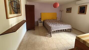 Une chambre à coucher comprenant un lit, une table de chevet, une armoire et une lampe suspendue rouge.