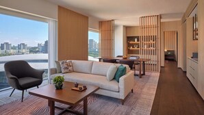 A modern living room with a sofa, coffee table, and a dining area with a table and chairs. - Hyatt Regency Kuala Lumpur At Kl Midtown (Kuala Lumpur)