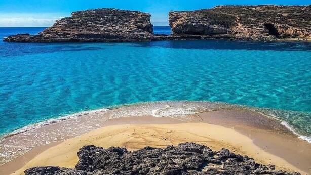 A beach with clear turquoise water, rocky formations, and a sandy foreground. - Charming 1-bedroom house with AC, WiFi in beautiful Birzebbugia (Birzebbugia)