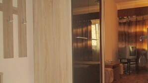 Eine moderne Küche mit Holzboden, einem Edelstahl-Kühlschrank und einem Essbereich mit Tisch und Stühlen.