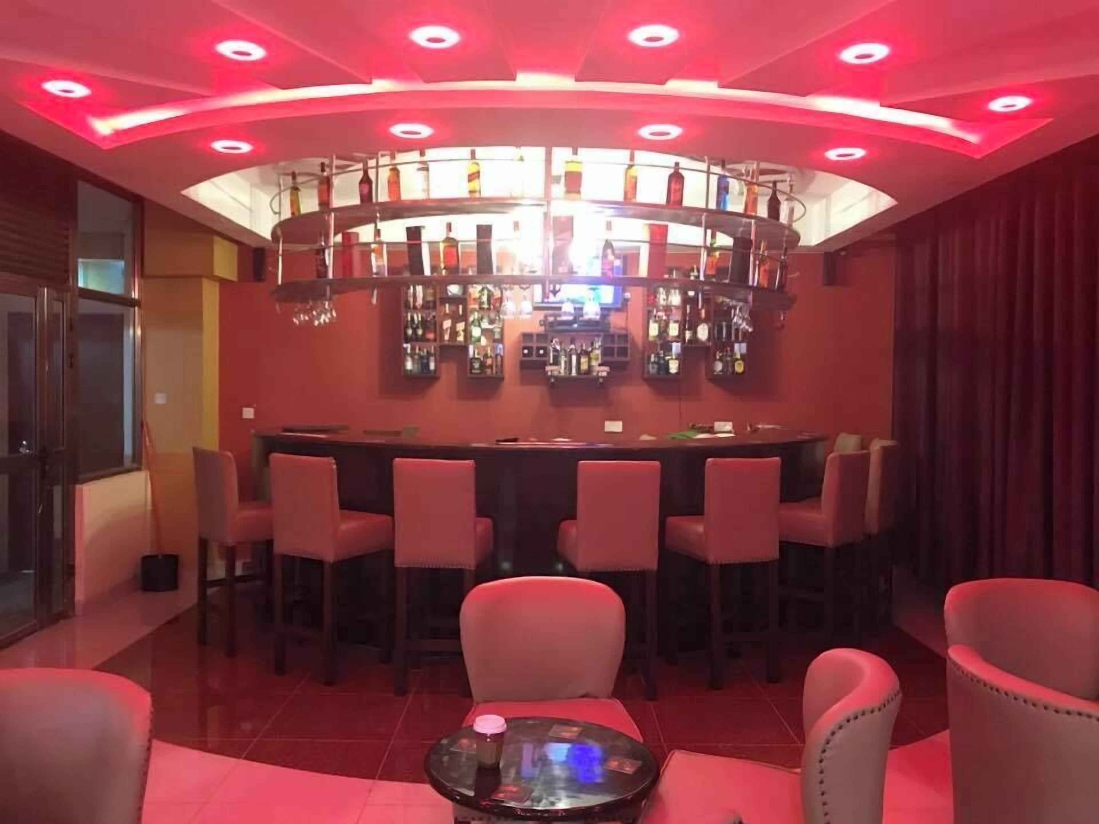 Eine Bar mit gewölbter Decke, zahlreichen Spirituosenflaschen und mehreren Barhocker.