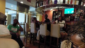 A bar area with seating and a television screen. - Miale Hotel  (Nakuru)